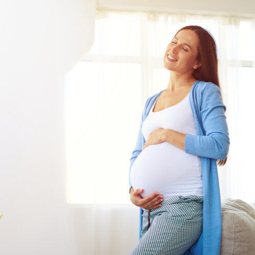 Pregnant Woman Enjoying Warm Sunset Light At Home